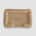 Tan plush bolster pet bed, top view showing ribbed corduroy texture and raised calming sides