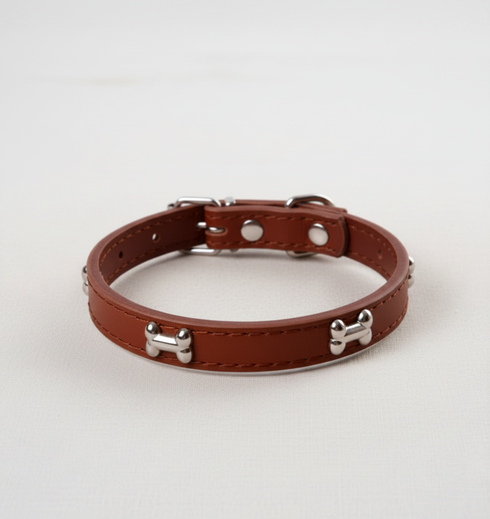 Brown leather dog collar with bone-shaped studs, flat product photo