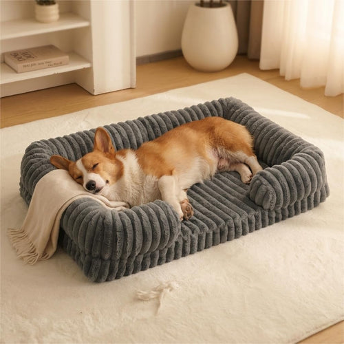 Corgi sleeping on a gray bolster dog bed